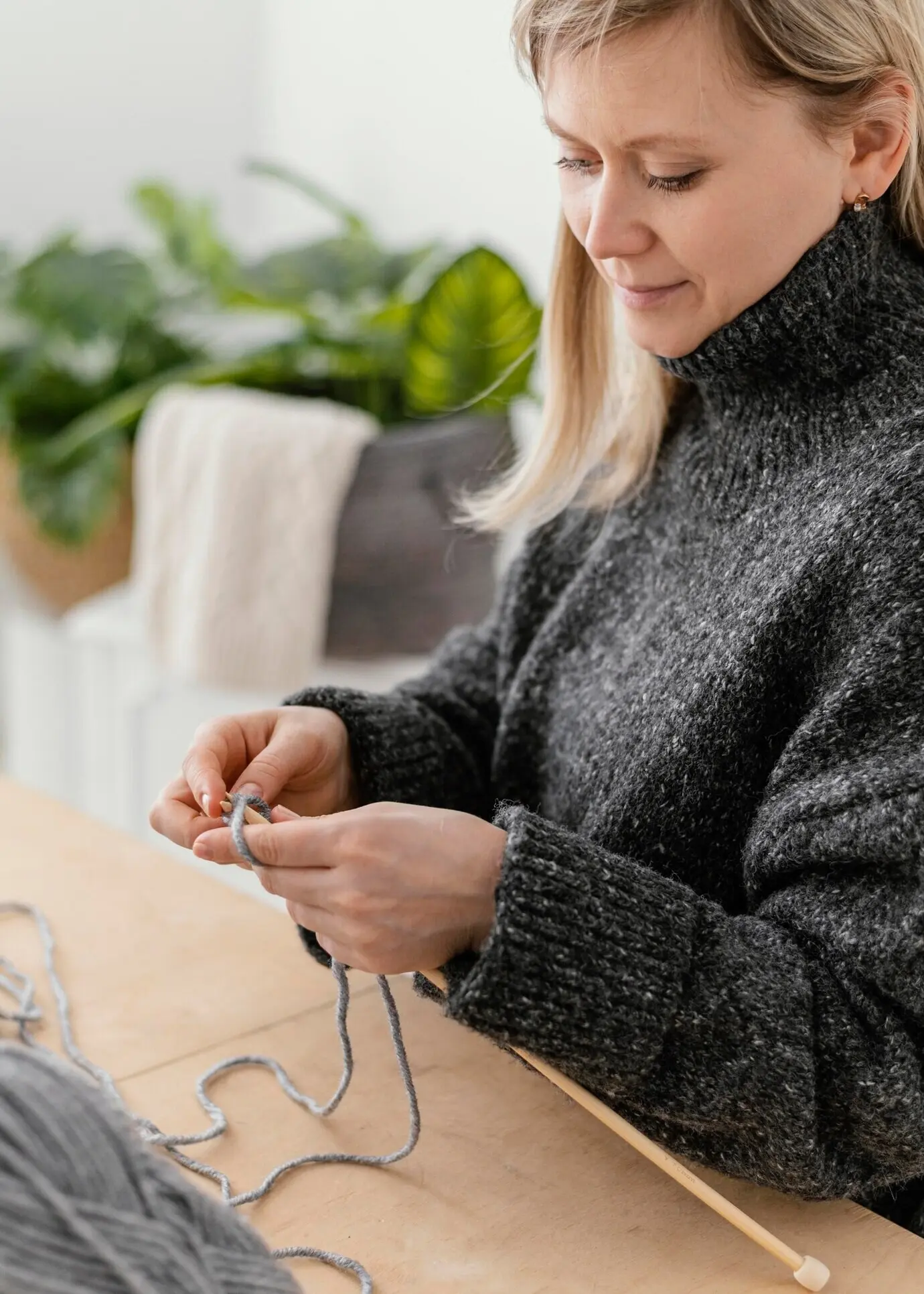 Nahaufnahme einer Frau beim Stricken zu Hause.